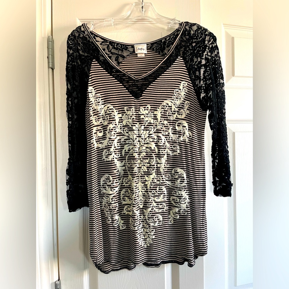 Daytrip size medium tee with black lace neckline and sleeves.